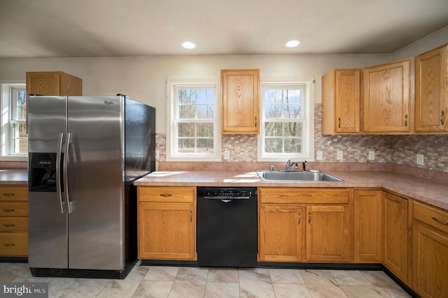 kitchen featuring stainless steel refrigerator with ice dispenser, dishwasher, sink, and tasteful backsplash