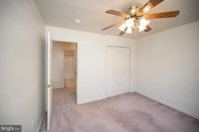 unfurnished bedroom with light carpet, a closet, and ceiling fan