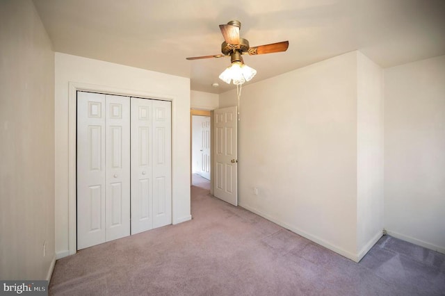 unfurnished bedroom with light colored carpet, ceiling fan, and a closet