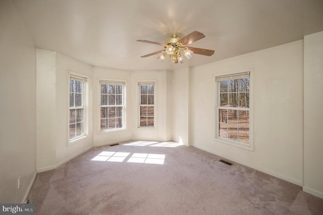 carpeted empty room featuring plenty of natural light and ceiling fan