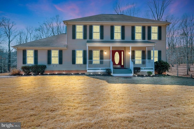 colonial house with a lawn and a porch