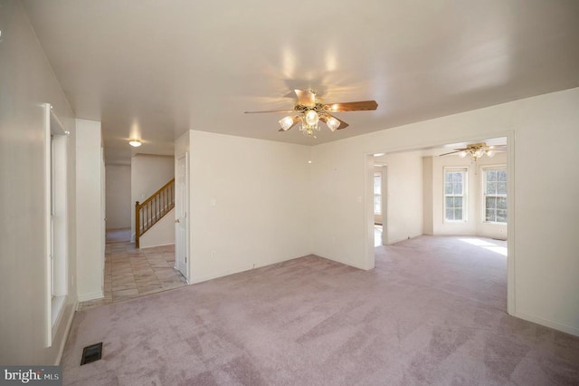 unfurnished room with light colored carpet and ceiling fan