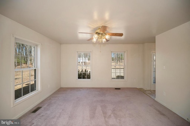 empty room featuring ceiling fan and light carpet