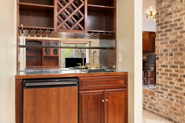 bar with dishwasher, brick wall, and sink