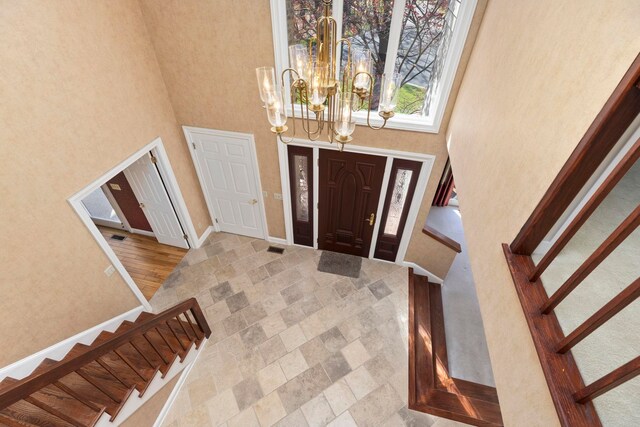 foyer entrance featuring a chandelier and a high ceiling