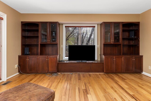 living room with a brick fireplace and light wood-type flooring