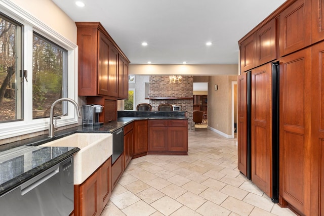 kitchen with sink, dark stone countertops, stainless steel dishwasher, paneled fridge, and a brick fireplace