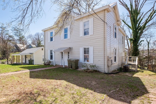 view of front of home featuring cooling unit and a front yard