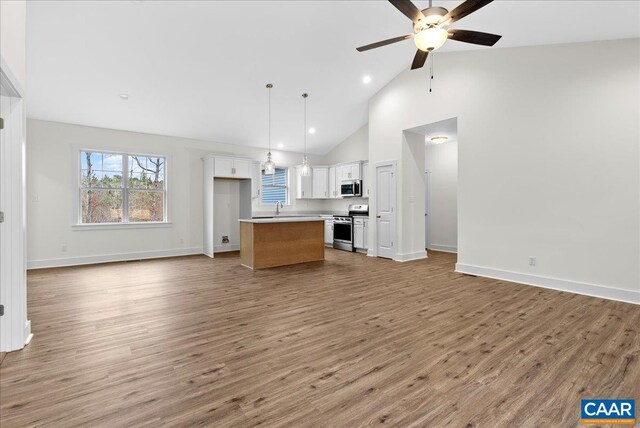 kitchen with light hardwood / wood-style flooring, hanging light fixtures, stainless steel appliances, a center island, and white cabinets