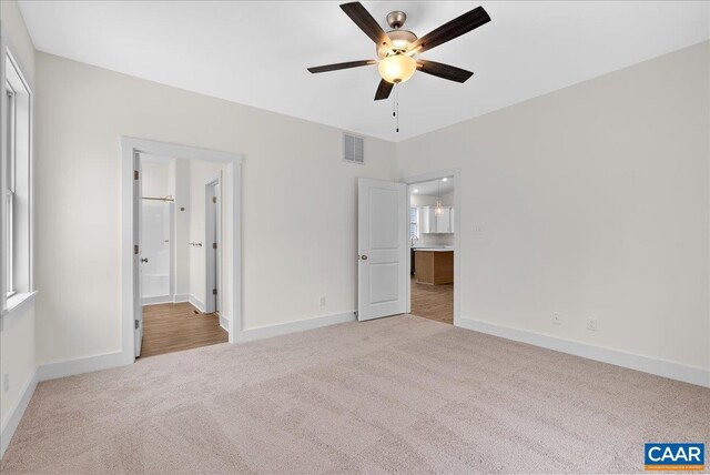 unfurnished bedroom with light colored carpet and ensuite bathroom