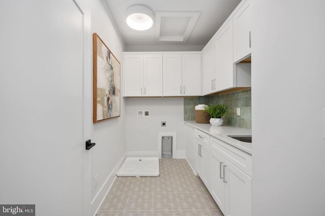 washroom featuring cabinet space, baseboards, hookup for an electric dryer, light floors, and washer hookup