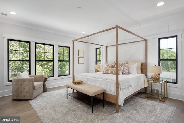 bedroom with visible vents, baseboards, ornamental molding, wood finished floors, and recessed lighting