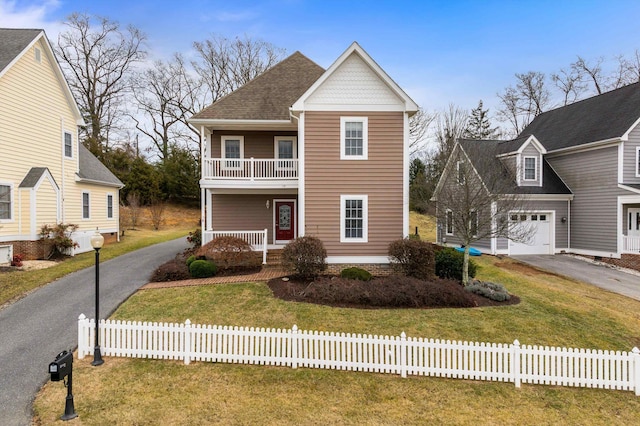 front of property with a balcony, a garage, covered porch, and a front yard