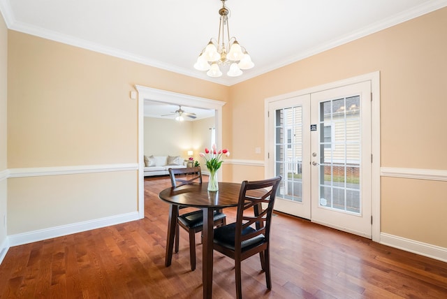 dining area with crown molding, hardwood / wood-style floors, a chandelier, and french doors