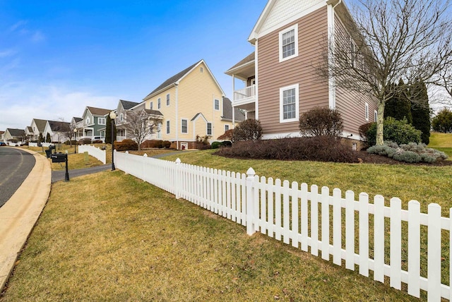 view of home's exterior with a balcony and a yard