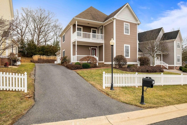 view of front of home featuring a balcony and a front yard