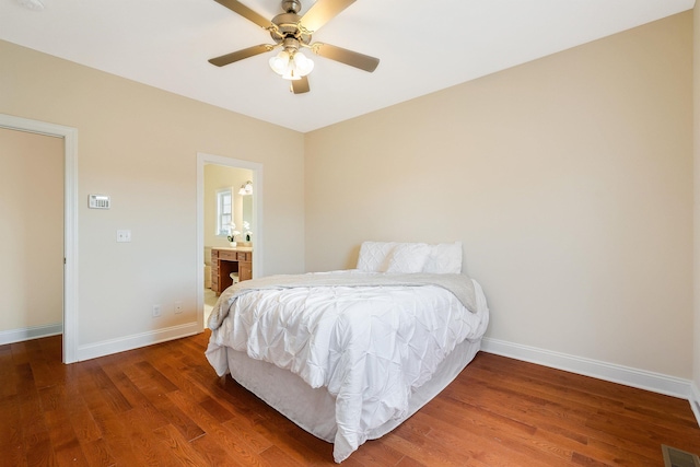 bedroom featuring ceiling fan, ensuite bathroom, and dark hardwood / wood-style flooring