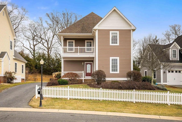 view of front of house with a porch, a balcony, and a front yard