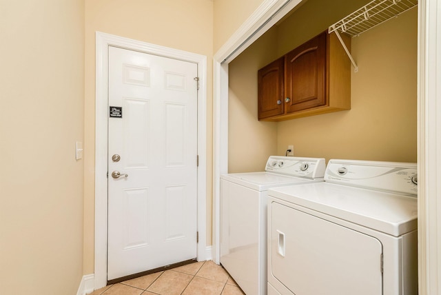 laundry area with cabinets, separate washer and dryer, and light tile patterned floors