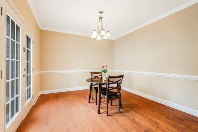 dining space with an inviting chandelier, hardwood / wood-style flooring, and ornamental molding