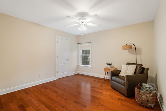 sitting room with ceiling fan and wood-type flooring