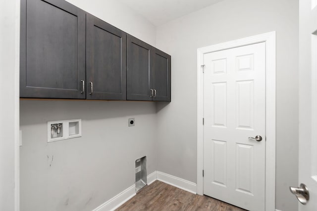 clothes washing area featuring cabinet space, baseboards, dark wood-type flooring, washer hookup, and electric dryer hookup