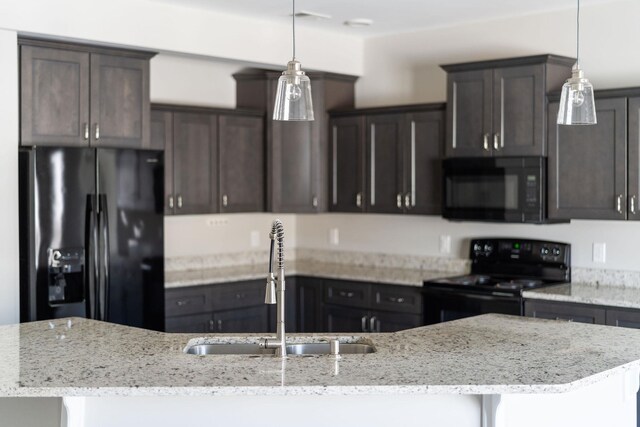 kitchen with light stone counters, dark brown cabinetry, and black appliances