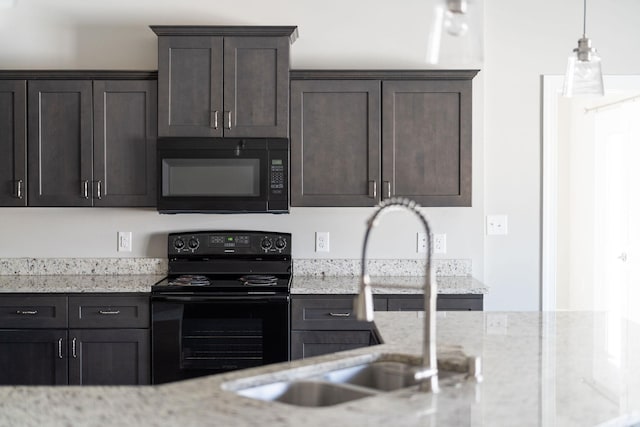 kitchen featuring light stone counters, sink, and black appliances