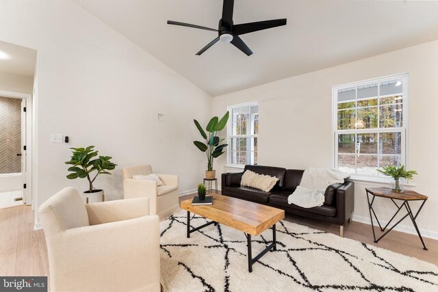 living room with ceiling fan, vaulted ceiling, and light hardwood / wood-style flooring