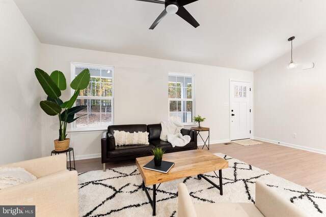 living room featuring lofted ceiling, light hardwood / wood-style floors, and ceiling fan