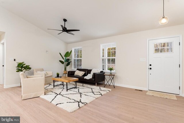 living room with vaulted ceiling, ceiling fan, and light wood-type flooring