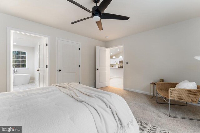 bedroom featuring ceiling fan, ensuite bathroom, and light carpet