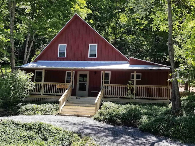 view of front facade featuring metal roof, a porch, and board and batten siding