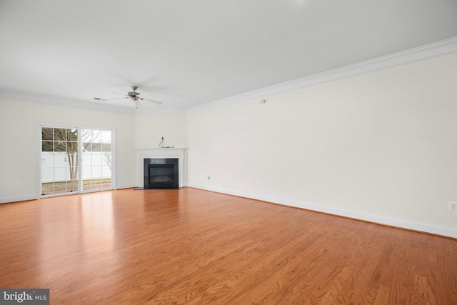 unfurnished living room featuring a fireplace with flush hearth, baseboards, light wood-style floors, and ornamental molding