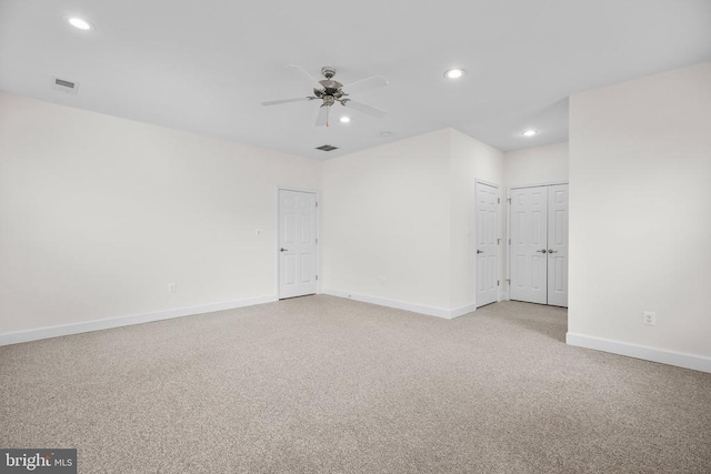 unfurnished room featuring recessed lighting, light colored carpet, visible vents, and baseboards