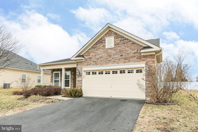 view of front of property with aphalt driveway, central air condition unit, an attached garage, and stone siding