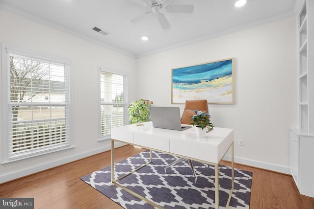 office area with visible vents, wood finished floors, baseboards, and ornamental molding