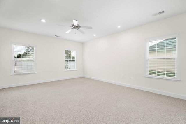 spare room with visible vents, baseboards, recessed lighting, ceiling fan, and light colored carpet