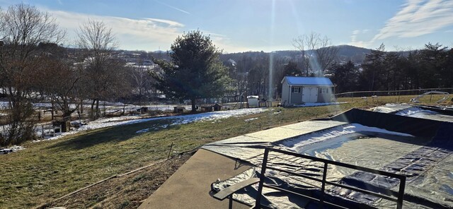 exterior space with a mountain view, a patio area, and a storage unit