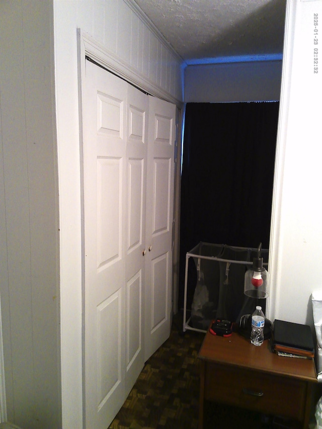 bedroom with a closet, dark parquet floors, and a textured ceiling