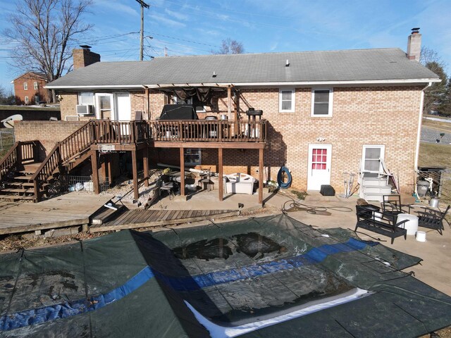 rear view of property featuring cooling unit, a deck, and a patio area