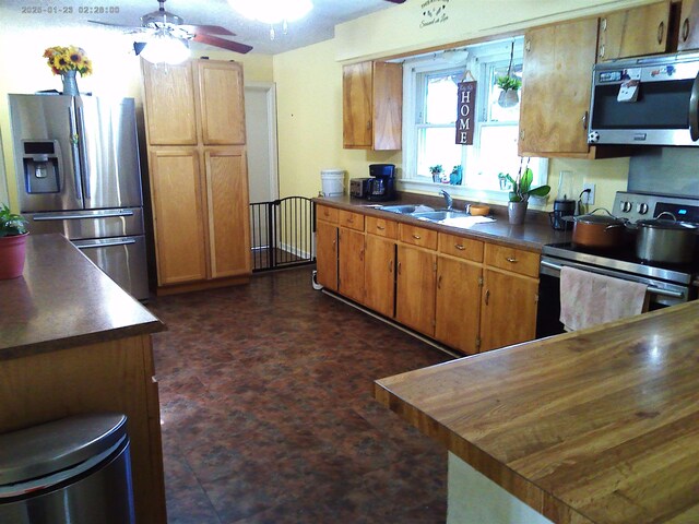 kitchen featuring stainless steel appliances, sink, and ceiling fan