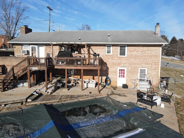 rear view of property with cooling unit, a wooden deck, and a patio