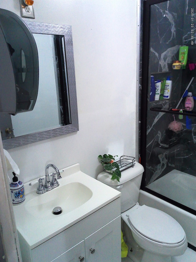 full bathroom featuring enclosed tub / shower combo, vanity, and toilet