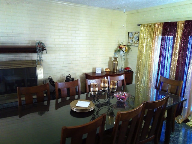 dining space featuring brick wall and a textured ceiling