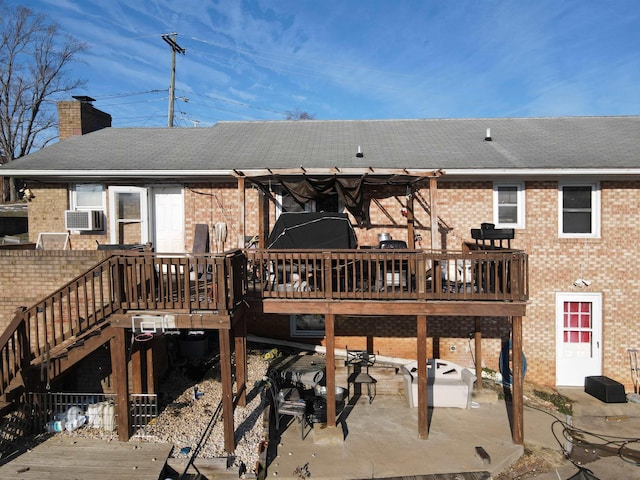 back of property with a wooden deck and a patio area