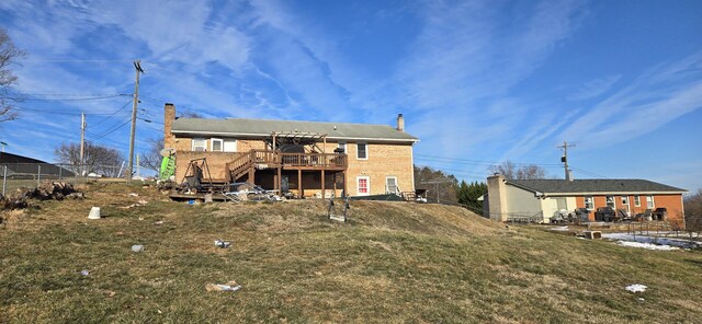 back of house featuring a deck and a lawn