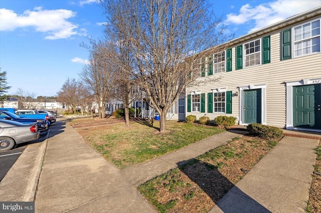 view of front of home with a residential view and a front yard