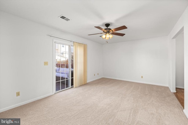 carpeted empty room featuring visible vents, baseboards, and a ceiling fan