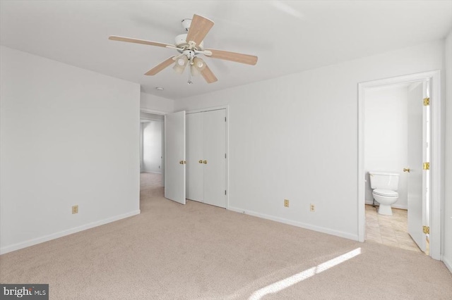 unfurnished bedroom featuring carpet flooring, ceiling fan, ensuite bath, and baseboards